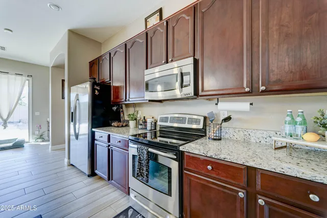 a kitchen with stainless steel appliances granite countertop wooden cabinets a stove top oven a sink and dishwasher