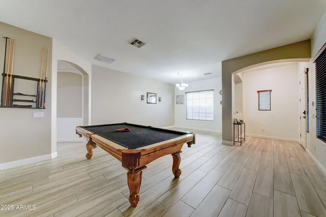 a room with wooden floor and pool table