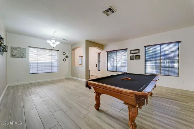 a room with wooden floor and pool table