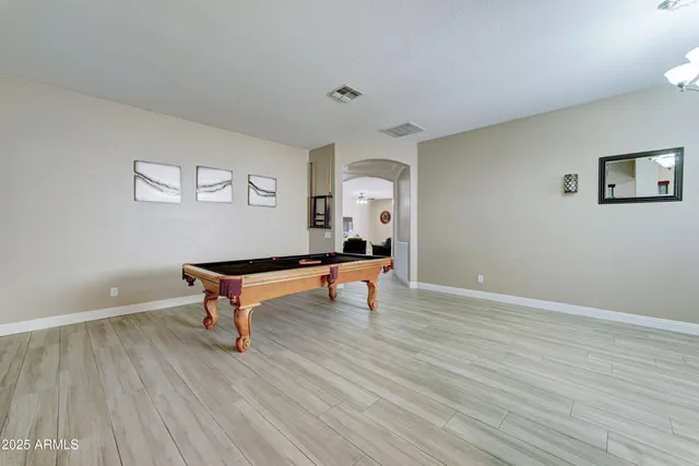 a room with wooden floor and pool table