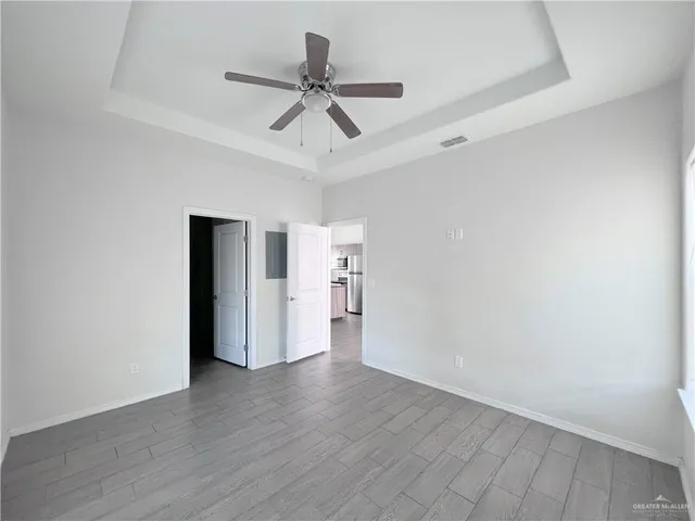 a view of a livingroom with wooden floor and a ceiling fan