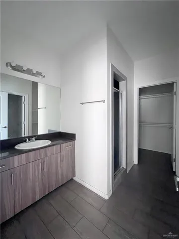 a spacious bathroom with a granite countertop sink and a mirror