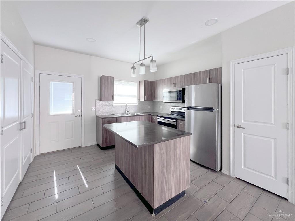 1609 West Cortlandt Street, Unit 3 Edinburg, TX 78541 - Photo 4 of 21 a kitchen with kitchen island granite countertop cabinets and refrigerator