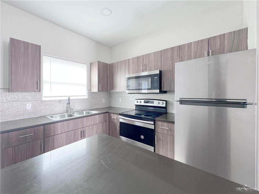 1609 West Cortlandt Street, Unit 3 Edinburg, TX 78541 - Photo 5 of 21 a kitchen with granite countertop a refrigerator stove and sink