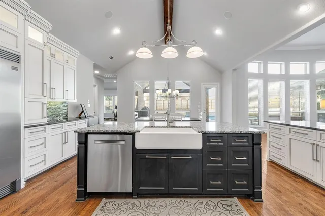 a large kitchen with granite countertop a stove a sink a dining table and chairs