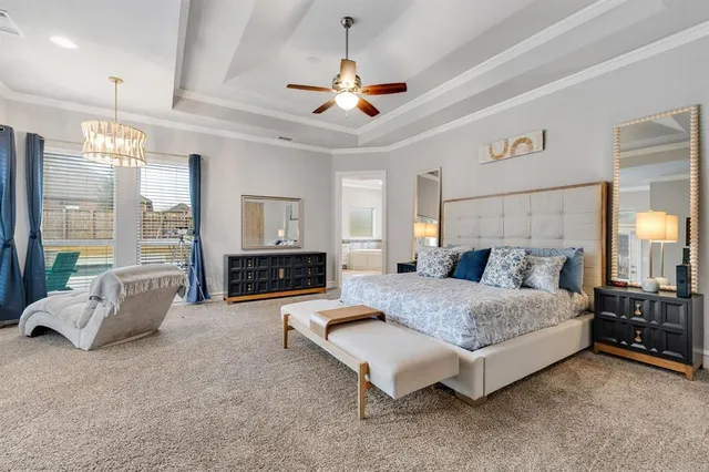 a spacious bedroom with a bed a couch and large window