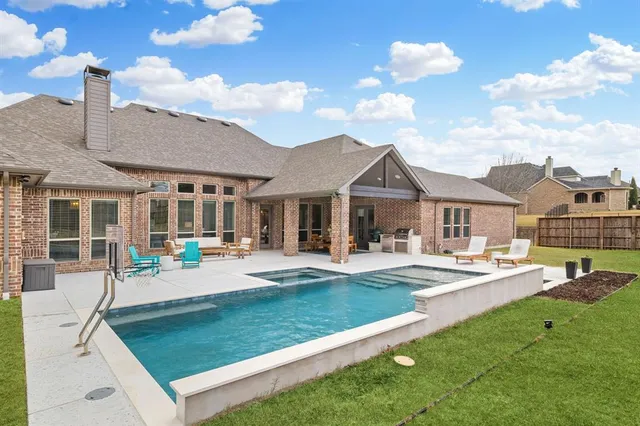 a front view of a house with swimming pool having outdoor seating