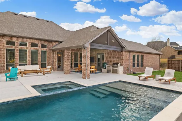 a view of a house with swimming pool and sitting area