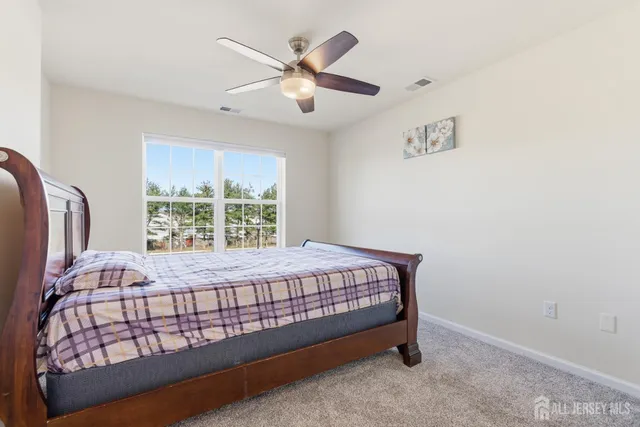 a bed sitting in a bedroom next to a window