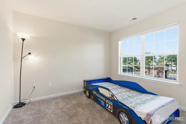 a view of a bedroom with a bed and a window