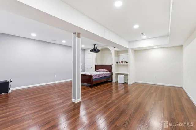 a bedroom with wooden floor and a bed