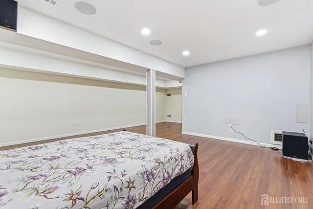 a bedroom with a bed and a wooden floor