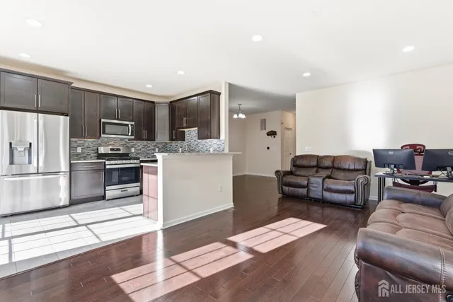 a living room with furniture and a kitchen counter space