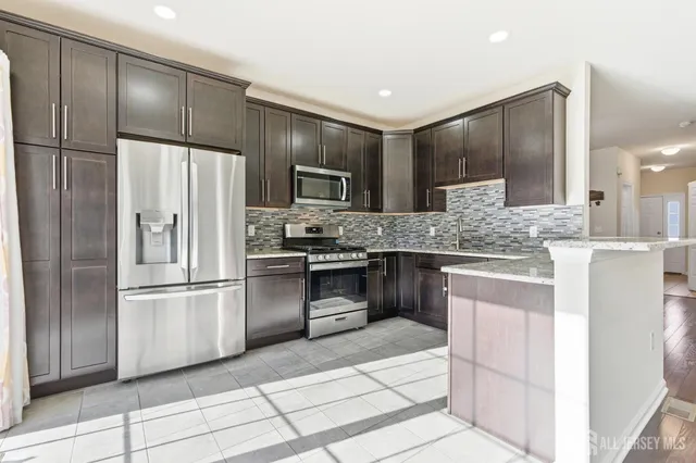 a kitchen with stainless steel appliances granite countertop a refrigerator and a sink