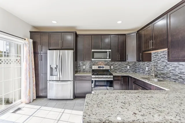 a kitchen with granite countertop a refrigerator and a sink