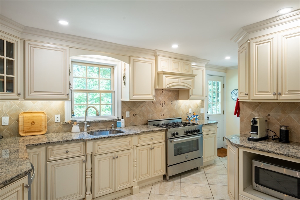 96 Conant Road Weston, MA 02493 - Photo 23 of 42 a kitchen with granite countertop white cabinets stainless steel appliances a sink and a window