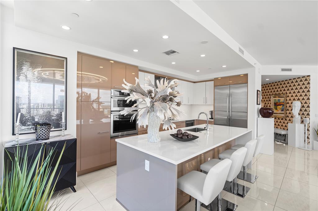 100 East Las Olas Boulevard, Unit 1901 Fort Lauderdale, FL 33301 - Photo 39 of 83 a kitchen with stainless steel appliances kitchen island granite countertop a table chairs and a refrigerator