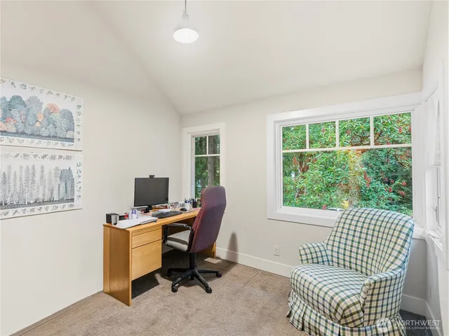 a view of a workspace with furniture and a window