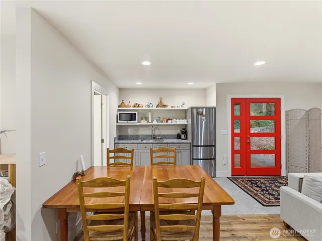 a living room with stainless steel appliances furniture and kitchen view