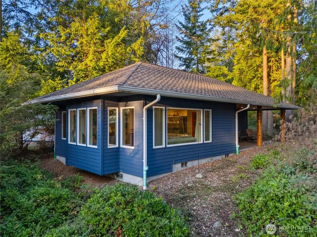 a front view of house with yard and trees in the background
