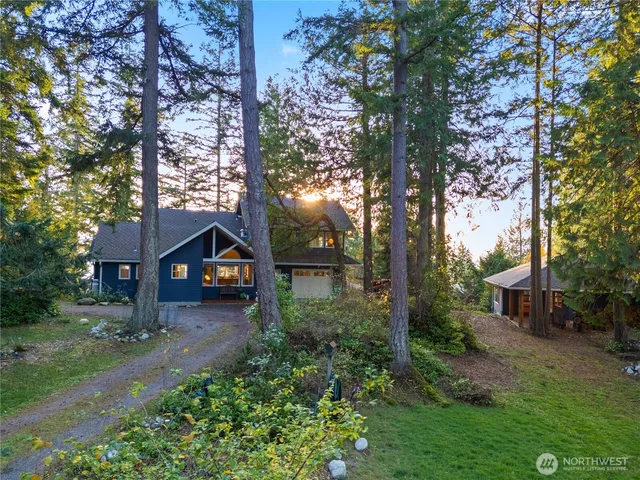 a front view of a house with a yard and tree