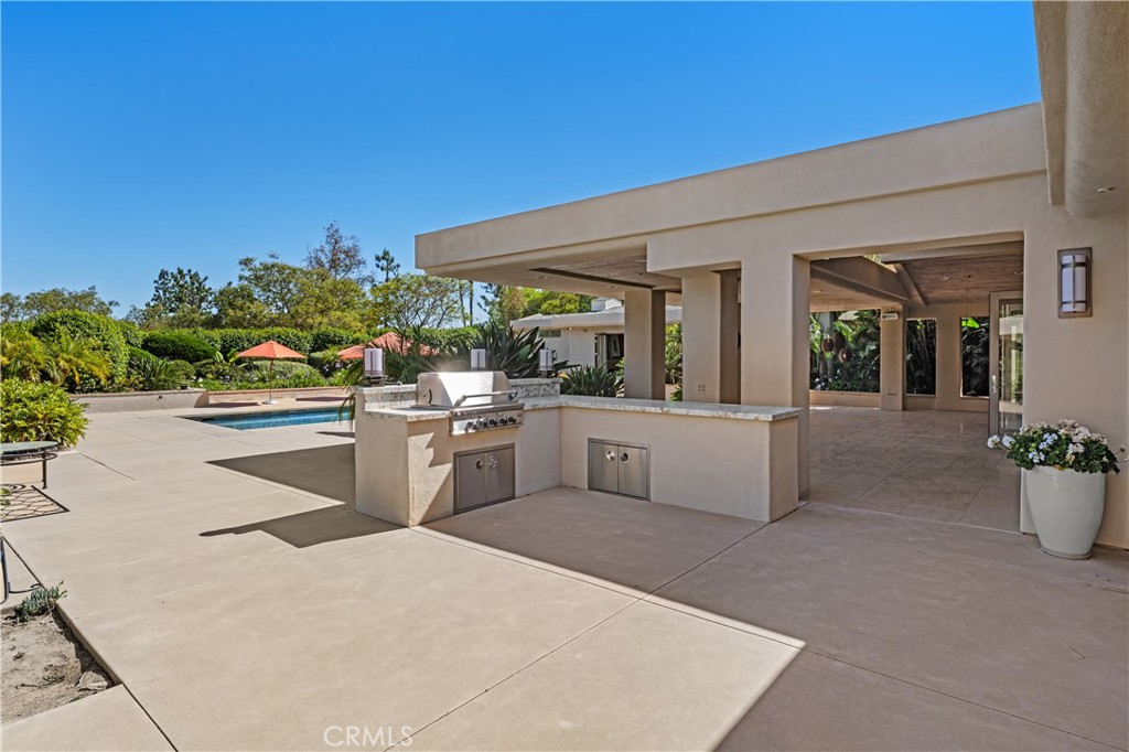 6533 Lago Lindo Rancho Santa Fe, CA 92067 - Photo 53 of 57 a living room with stainless steel appliances kitchen island granite countertop a stove a sink and a white countertops with wooden floor