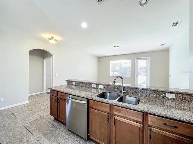 a kitchen with granite countertop a sink and a wooden cabinets