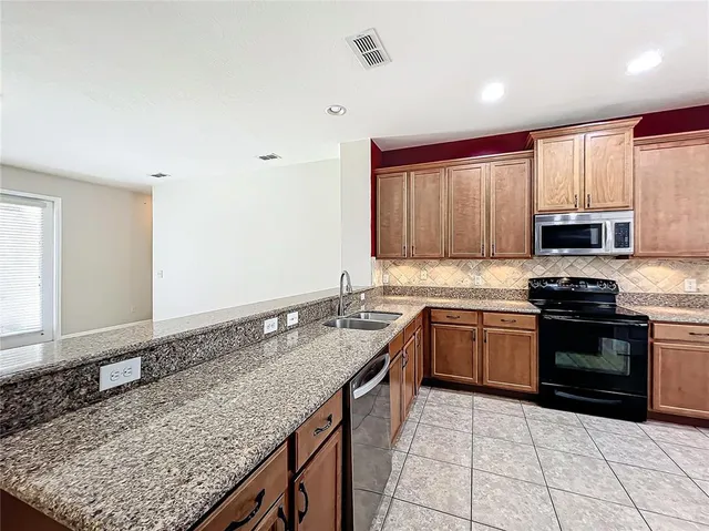 a kitchen with stainless steel appliances granite countertop a stove sink and microwave
