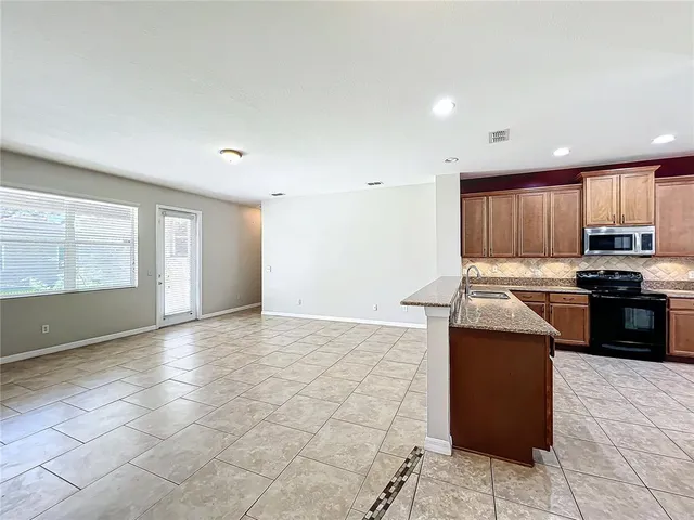 a kitchen with stainless steel appliances granite countertop a stove a sink and a refrigerator