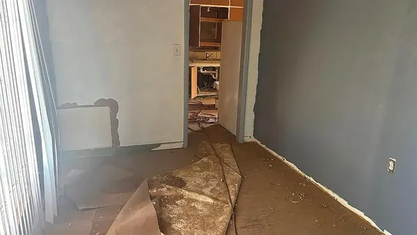 a view of a hallway with wooden floor and cabinet