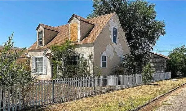 a white house that has tree in front of it
