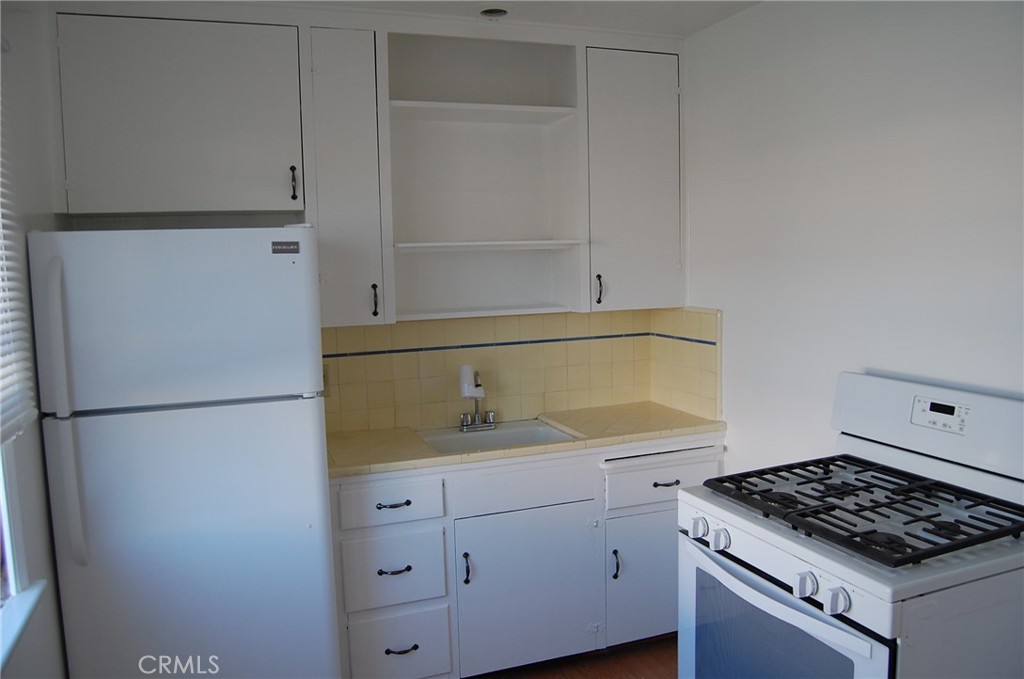 20 Roycroft Avenue Long Beach, CA 90803 - Photo 17 of 22 a kitchen with a refrigerator and a stove