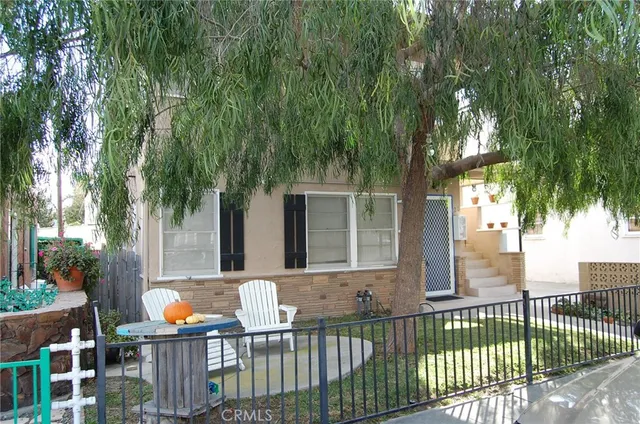 a outdoor view of a house with wooden fence and plants