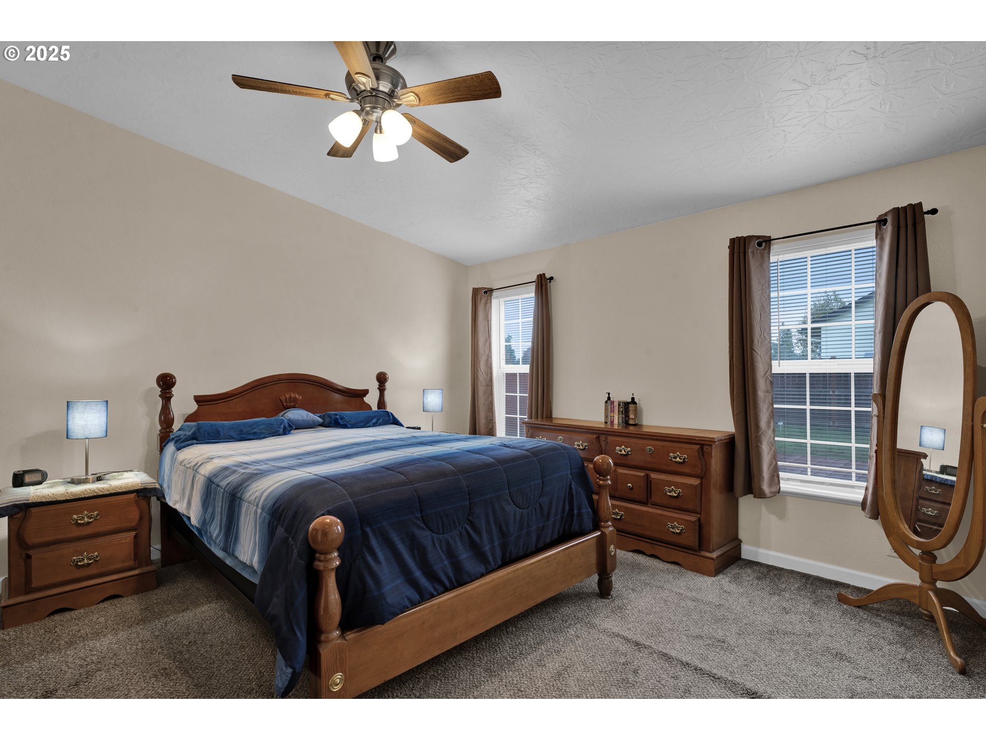 346 East 10th Place Junction City, OR 97448 - Photo 26 of 39 a bedroom with a bed a mirror and a dresser with wooden floor