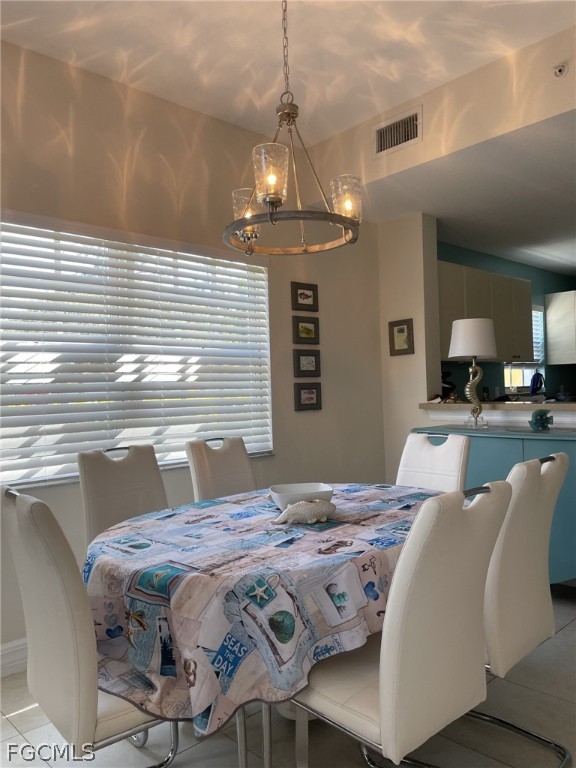 4500 Botanical Pl Circle, Unit 107 Naples, FL 34112 - Photo 24 of 39 a bedroom with a bed a chandelier and a view of the kitchen