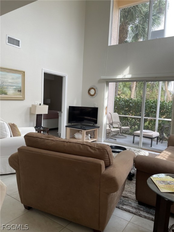 4500 Botanical Pl Circle, Unit 107 Naples, FL 34112 - Photo 7 of 39 a living room with furniture a flat screen tv and a large window