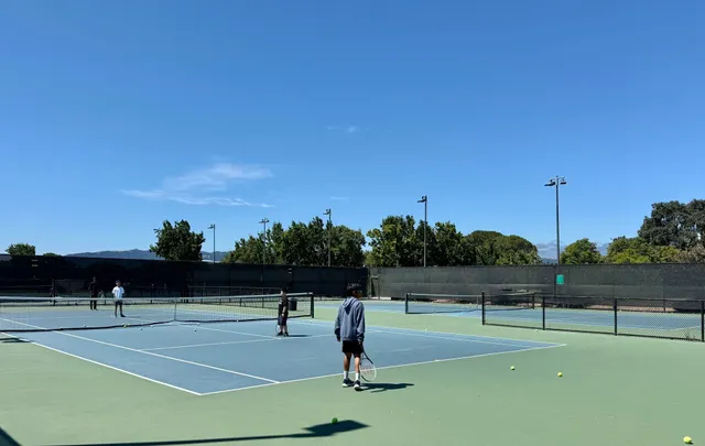 a tennis court with view of trees in the background
