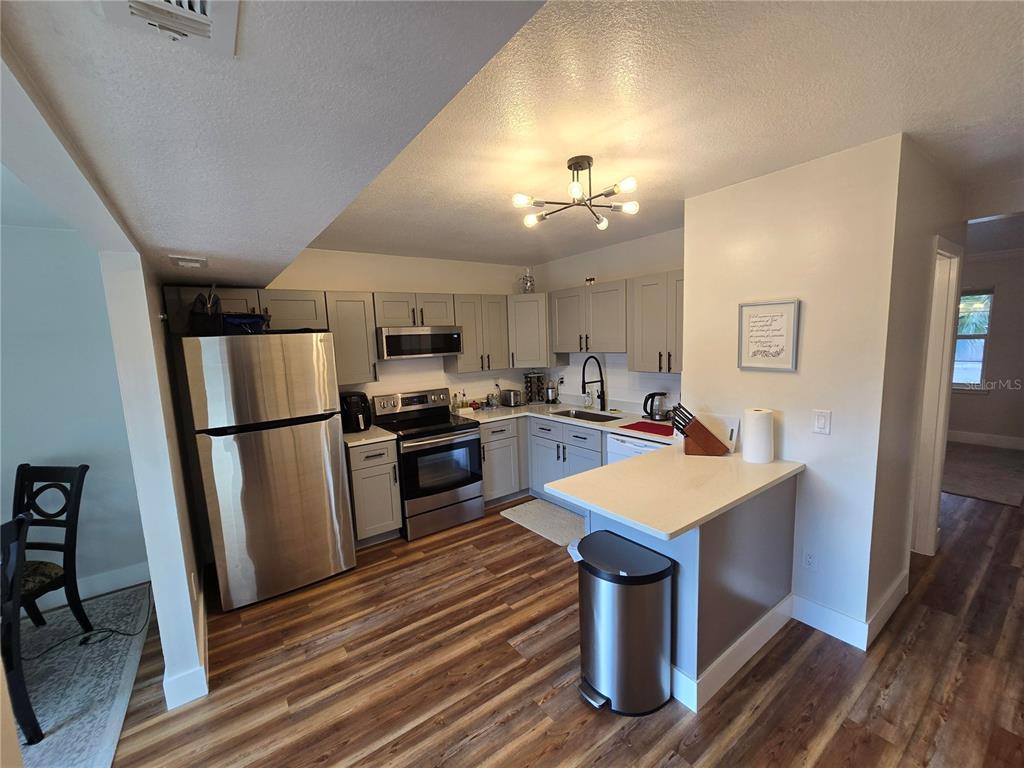 820 West 25th Street Sanford, FL 32771 - Photo 11 of 23 a kitchen with refrigerator cabinets and wooden floor