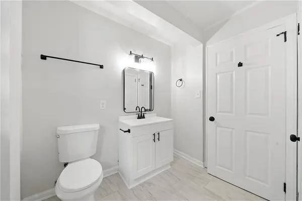 a bathroom with a toilet a sink and mirror
