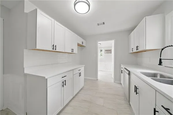 a kitchen with cabinets appliances a sink and a counter top space