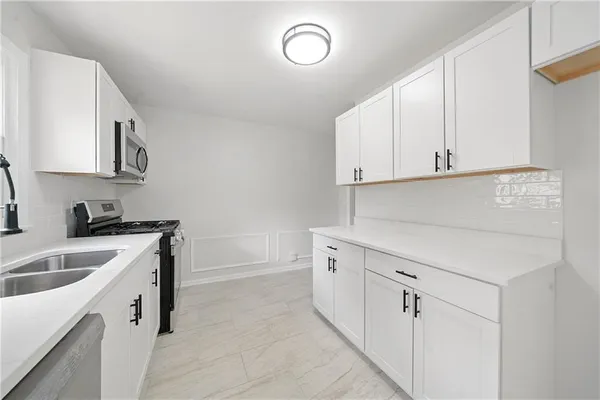 a kitchen with cabinets appliances and a sink