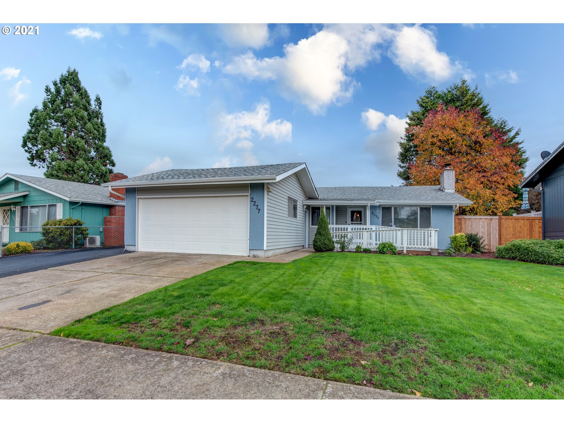2277 11th Street Springfield, OR 97477 - Photo 1 of 24 a front view of a house with a garden and trees