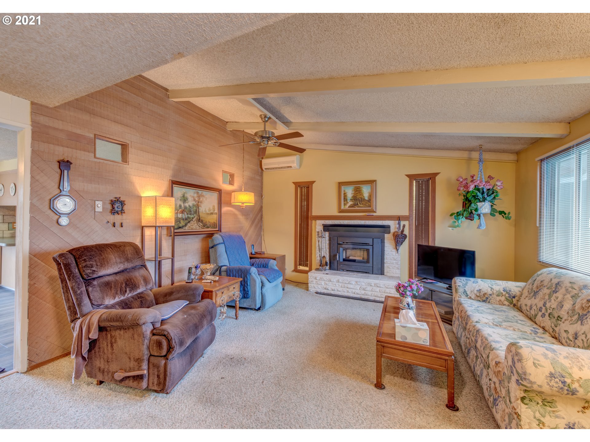 2277 11th Street Springfield, OR 97477 - Photo 4 of 24 a living room with furniture a fireplace and a flat screen tv