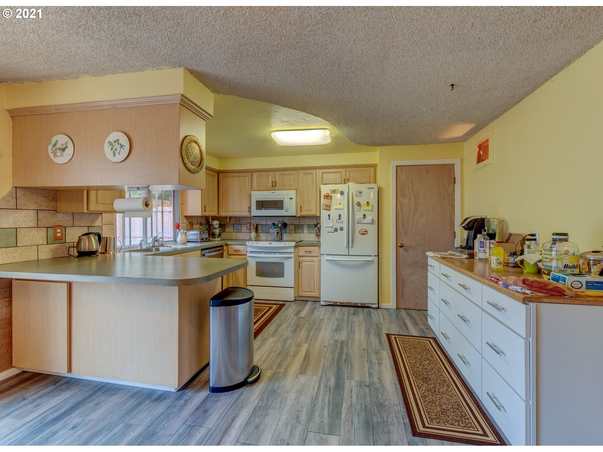 2277 11th Street Springfield, OR 97477 - Photo 6 of 24 a kitchen with white cabinets and wooden floor