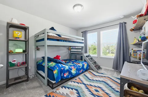 a bedroom with a bed and a flat tv screen on dresser