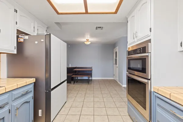 a kitchen with granite countertop a refrigerator and a stove top oven