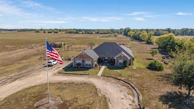 an aerial view of a house with swimming pool and patio