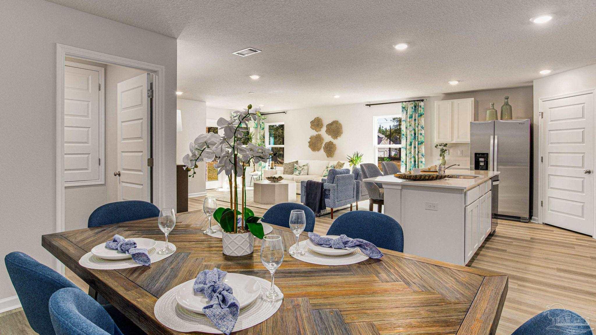 9732 Dutton Lane Milton, FL 32583 - Photo 2 of 24 a view of a dining room with furniture a kitchen and chandelier