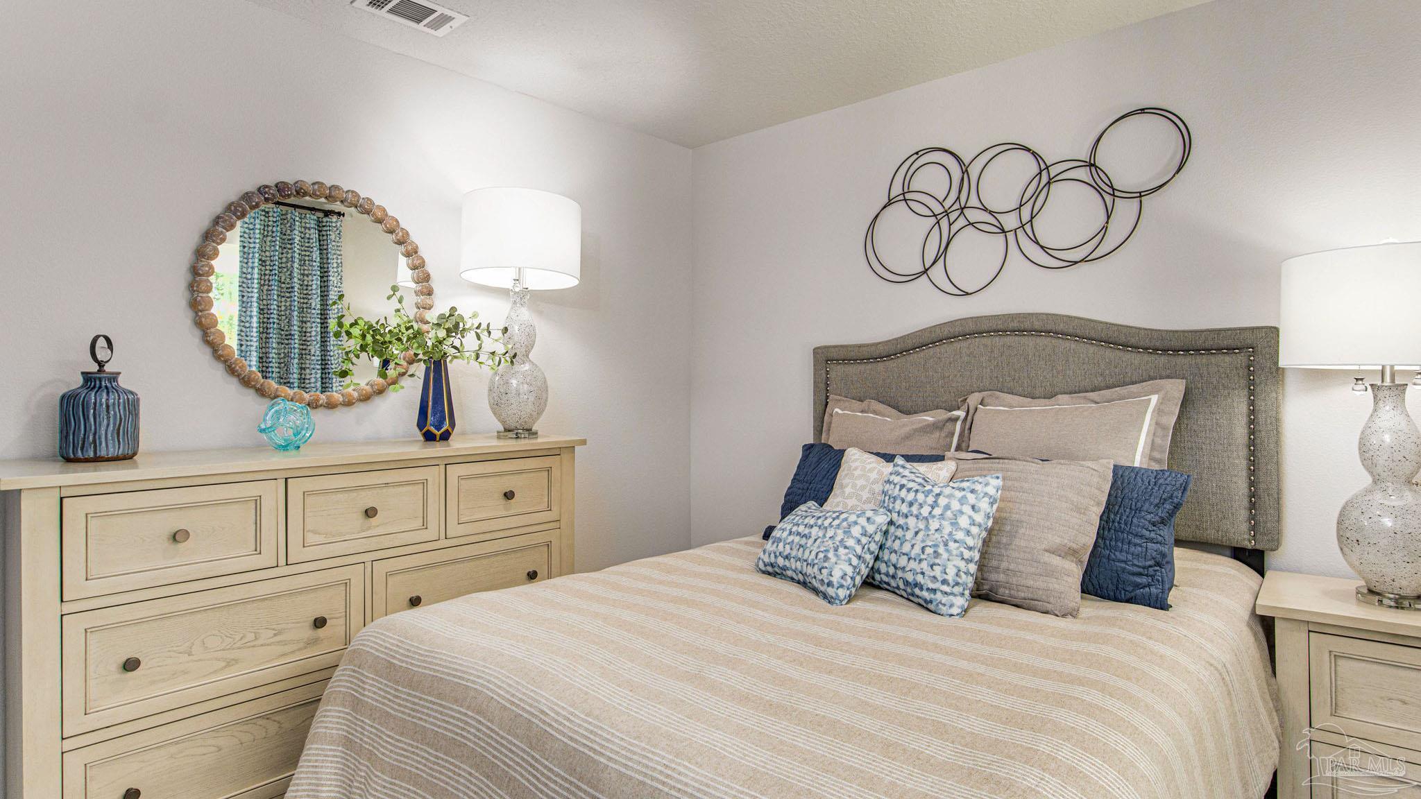 9732 Dutton Lane Milton, FL 32583 - Photo 22 of 24 a bedroom with a bed and a mirror on the dresser