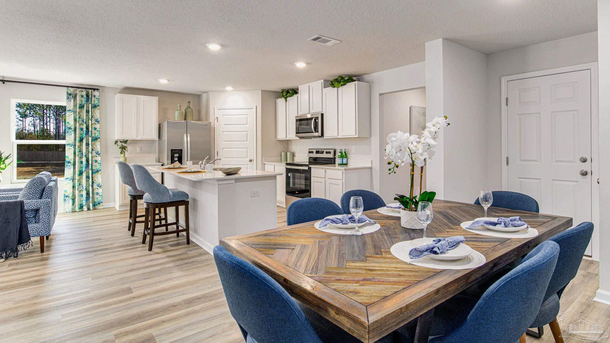 9732 Dutton Lane Milton, FL 32583 - Photo 4 of 24 a view of a dining room with furniture and wooden floor